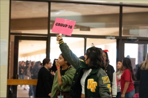 Sophomore Isabella Rios holds up Group 16 sign as she leads her group of eighth graders around the school.