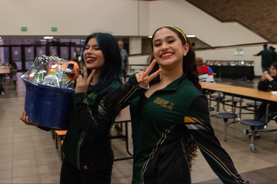 As part of the event, freshman Isabel Espinosa and sophomore Kaley Tellez Rodriguez walk around showing the guests the baskets up for the silent auction. 