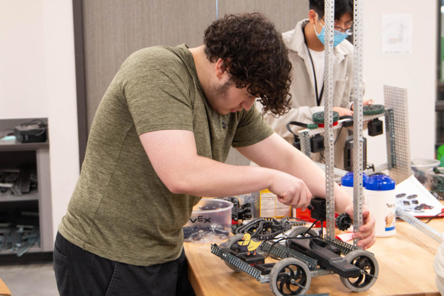 Focused on his task, senior Janmarcos Vasquez screws in locks to connect a metal rod to their robot.