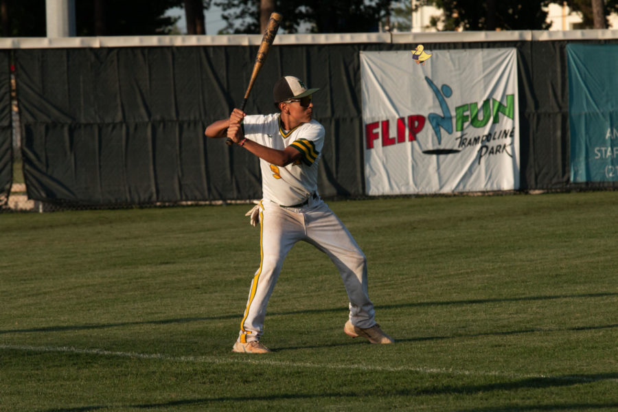 Preparing for the game, freshman Fernando Vasquez practices on batting. 