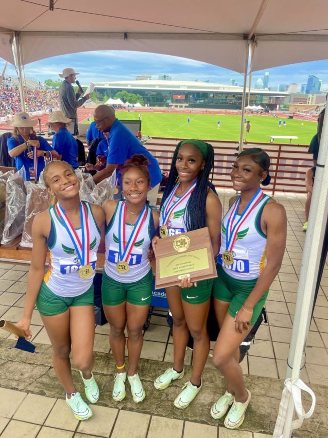 Sophomore Kyaliah Davis, junior Avia Jones, and seniors CNai Childress, and Nia Hampton pose with their medals and trophy after winning the title of State Champion of the 4x200m relay race.