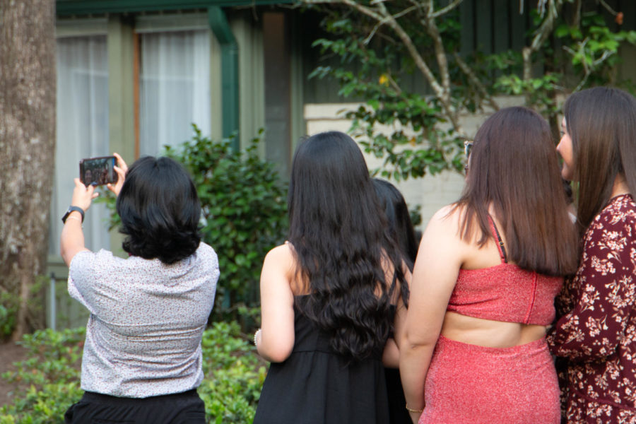 Senior Jo Hernandez holds up the phone for a group photo with staff and guests.