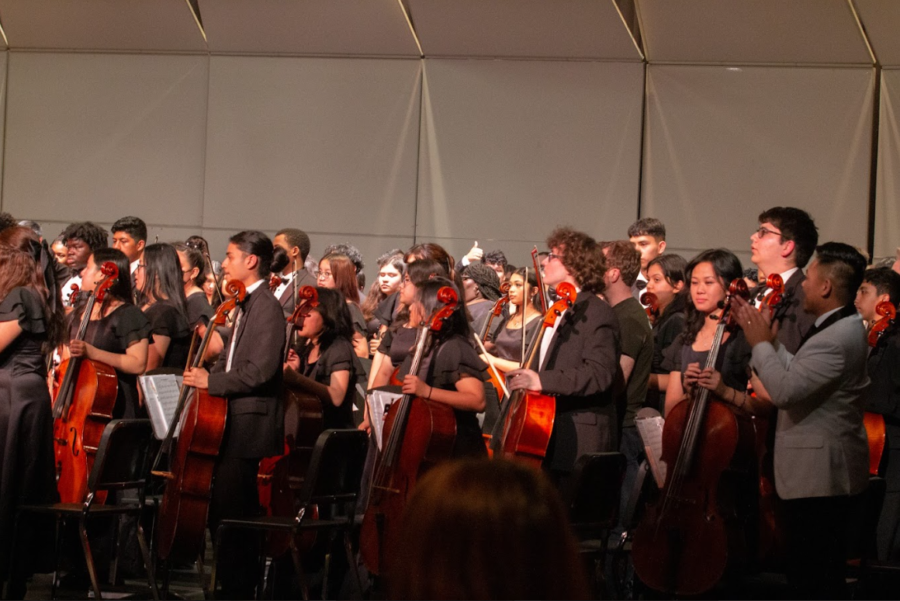 The all-combined orchestra and alumni stand as the spring concert concluded. 
