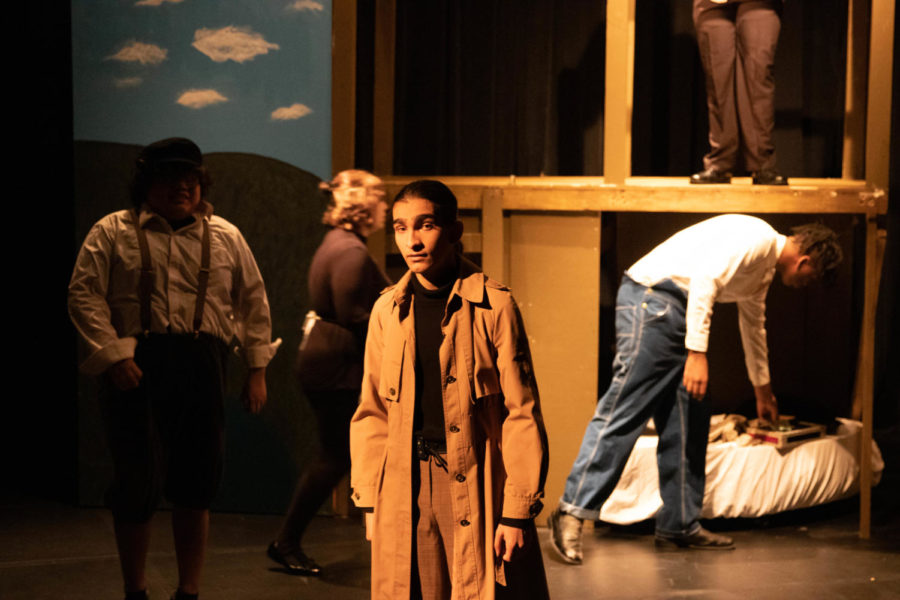Freshman James Rahman narrates the scene transition in the story as characters move into position in the background.