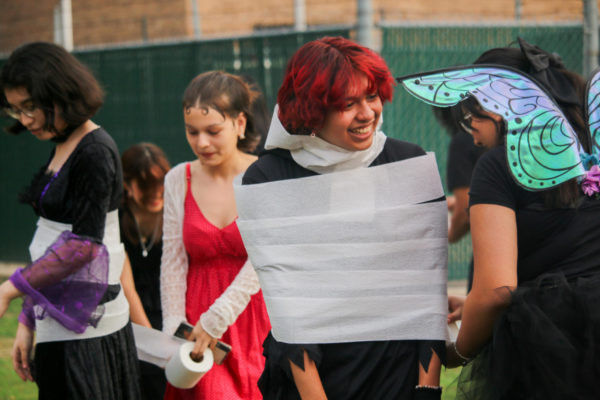 Sophomore Kamilah Medrano mummifies Sophomore Erik Valdez using toilet paper at the Orchestra Costume Party on Oct. 6.