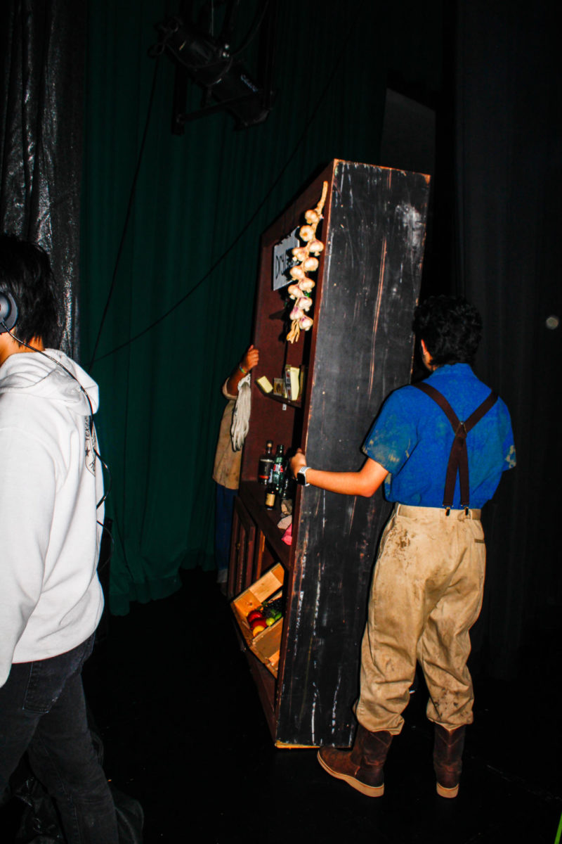 Hands on the Normas Dry Goods set, senior Denzel Arredondo and sophomore Randy Angel Martinez prepares to move the set onto the stage.