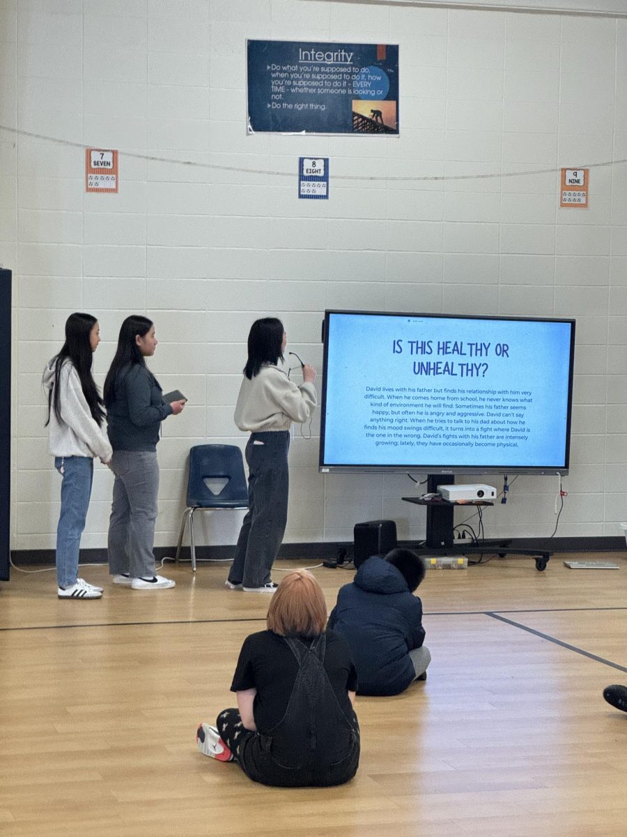 Juniors Kennedi Nguyen, Emily Vo, and Hayley Tu teach Greenwood Elementary students about healthy and unhealthy relationships. 