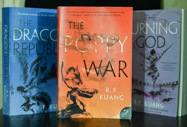 Placed in the center, The Poppy War is surrounded by the second and third book in the Poppy War trilogy. The Poppy War is R.F. Kuangs debut novel. that is followed by The Dragon Republic and The Burning God.